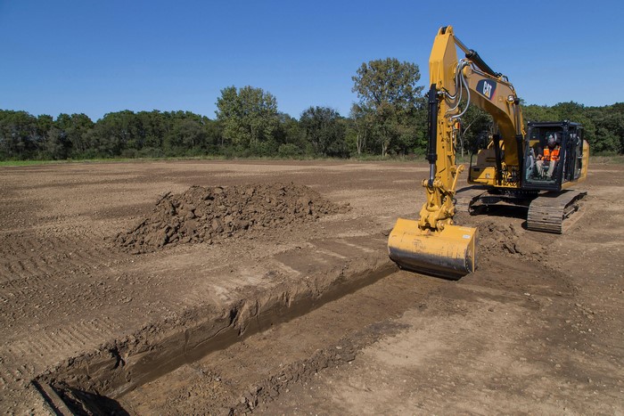 Caterpillar 323F L Excavator Digging Trench in Field