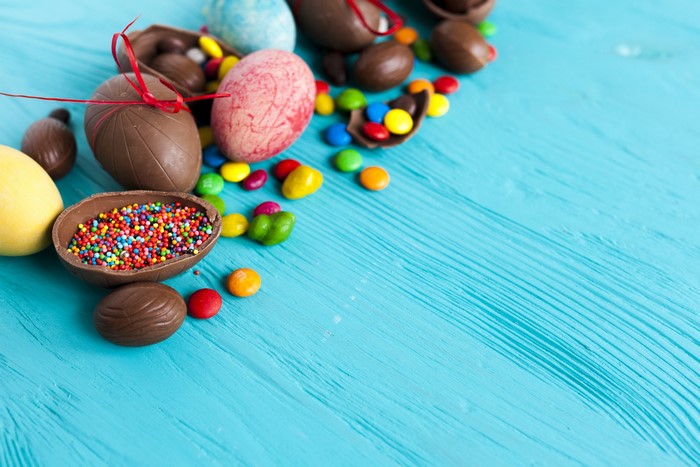 Easter chocolate eggs and candies on a blue wooden background