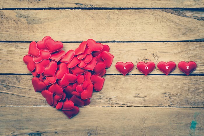 Heart made of red hearts and the word LOVE on wood planks