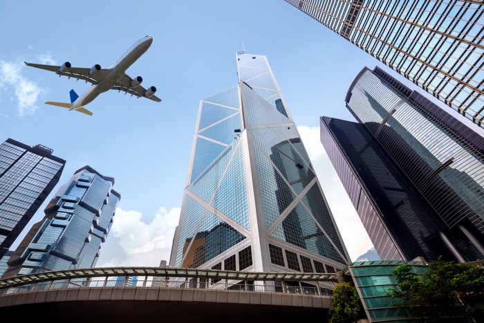 Airplane flying over skyscrapers in Hong Kong