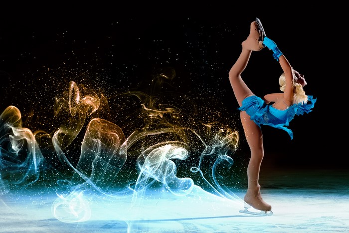 Figure skater in blue costume performing on ice with smoke effects