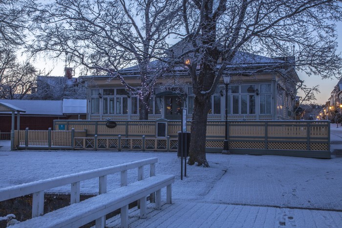 Snowy winter scene in Naantali, Finland with a wooden house and fence