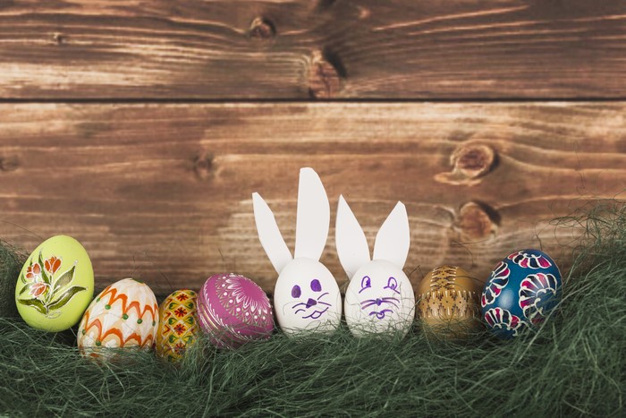 Easter eggs and bunny decorations on grass with wood background