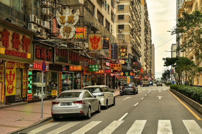 Street scene in Macao with neon signs and cars