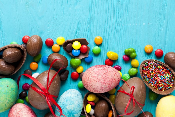 Easter chocolate eggs and candies on blue background