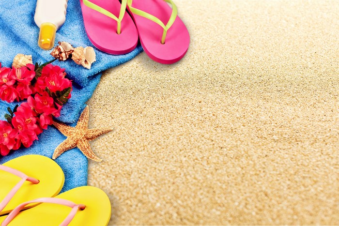 Beach accessories on sand with flip-flops and starfish