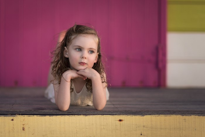 Little girl lying on wooden planks