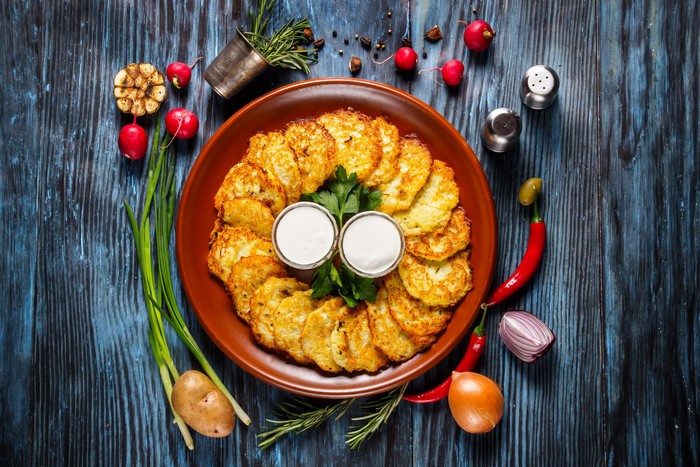 Potato pancakes with sour cream on a wooden table