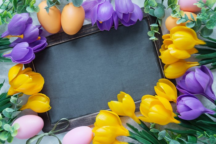 Easter eggs and crocuses around a chalkboard template
