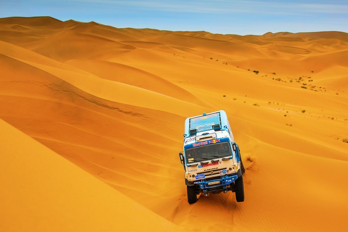 KAMAZ truck driving through desert dunes