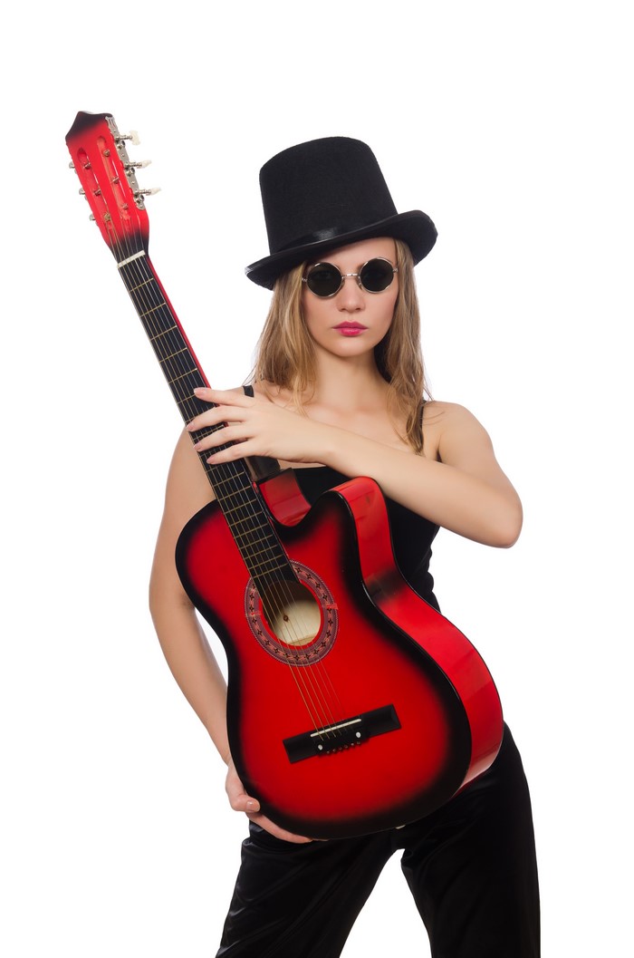 Woman in top hat and sunglasses holding a red guitar