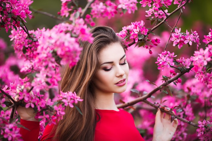 Woman in red dress among pink flowering branches