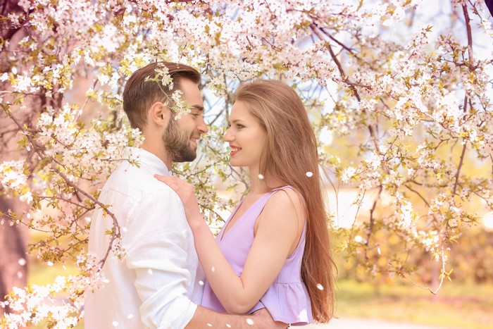 Couple Embracing Under Flowering Trees