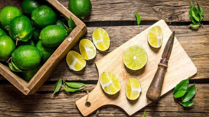 4K Limes on Wood Planks with Cutting Board
