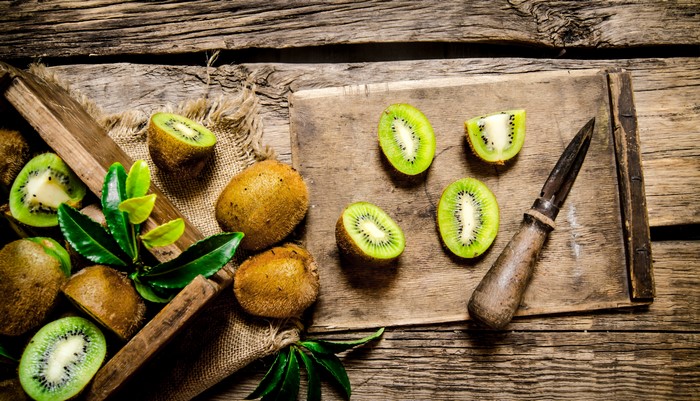 Kiwi fruit on wooden planks with knife