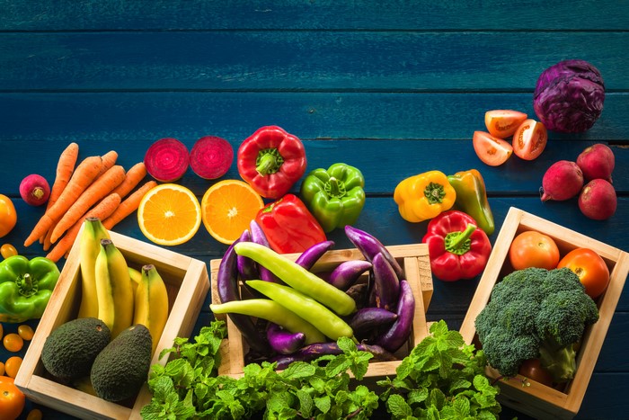 Assortment of fresh vegetables and fruits on a blue wooden table
