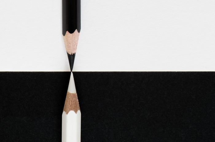 Black and white pencils meeting at a point