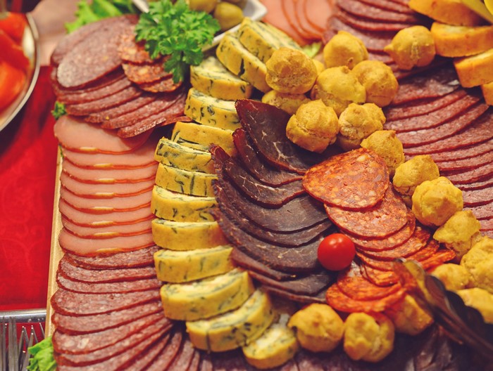 Assortment of sliced meats, cheese rolls, and bread rolls