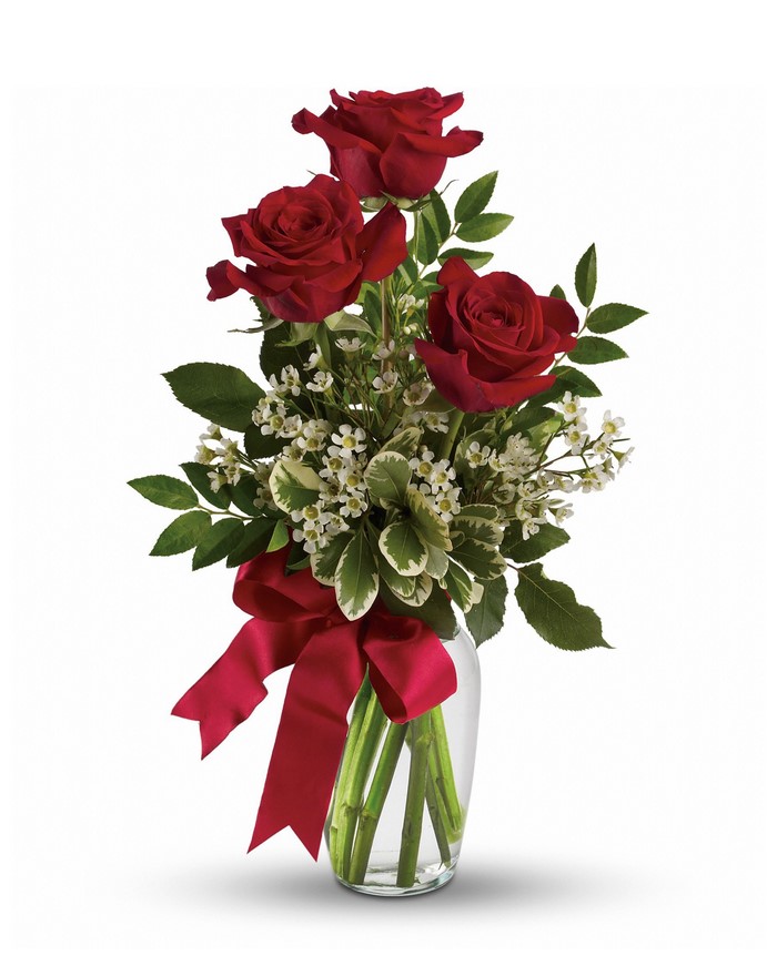 Three red roses in a vase with a red bow