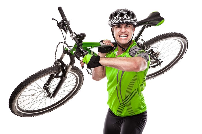 Man carrying a bicycle wearing a helmet