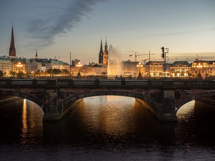 Hamburg skyline with bridge over river at dusk