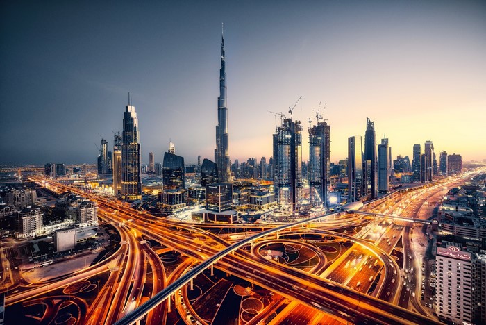 Dubai city skyline with Burj Khalifa and highway at dusk