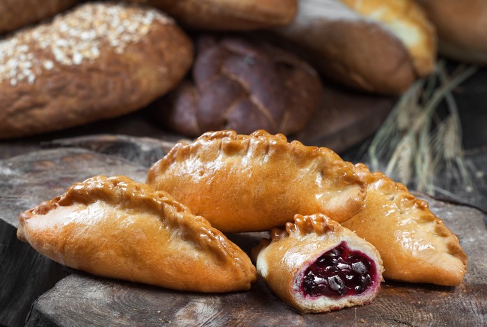 Baked cherry pies on a wooden surface