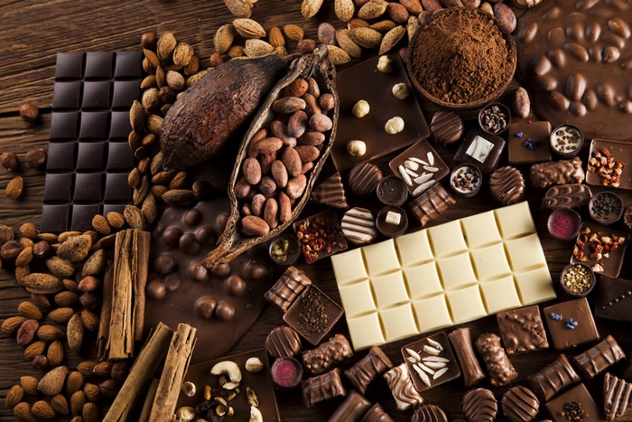 Assortment of chocolates, cocoa beans, nuts, and cinnamon sticks