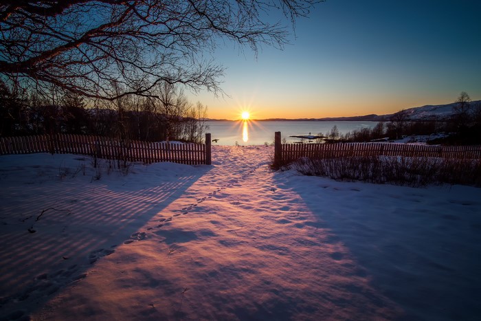 Sunrise over a snowy landscape with a fence in Sulitjelma, Norway