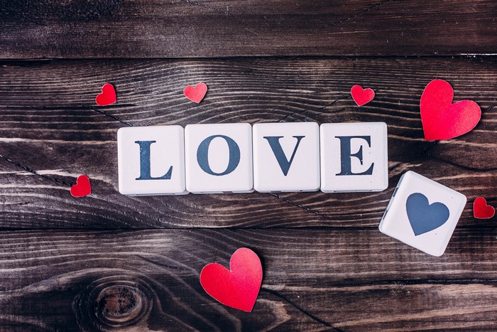 Love spelled with blocks and hearts on wood