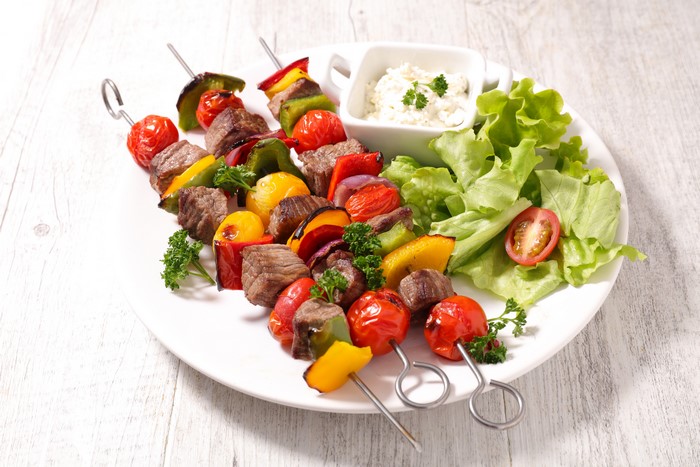 Meat and vegetable shashlik on a plate with salad
