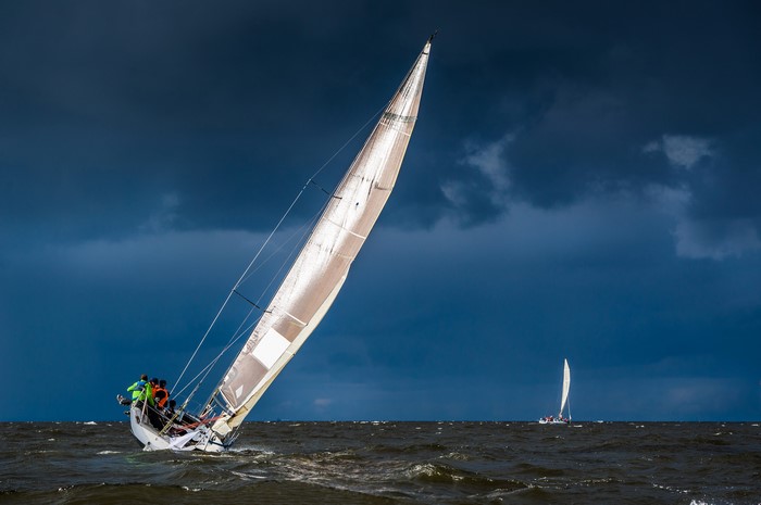 Sailboats racing on choppy water under stormy skies