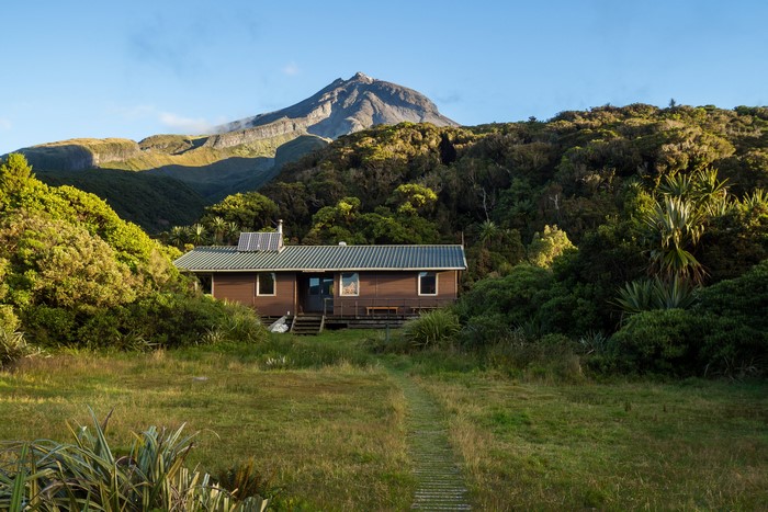 Wooden cabin in front of Mount Egmont, Taranaki, New Zealand