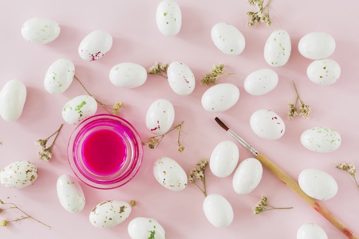Easter Eggs and Paintbrush on Pink Background