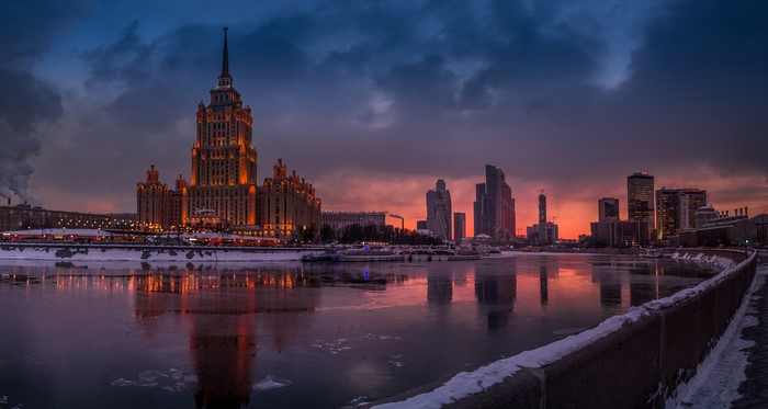 Moscow skyline with Stalinist skyscraper and river at dusk