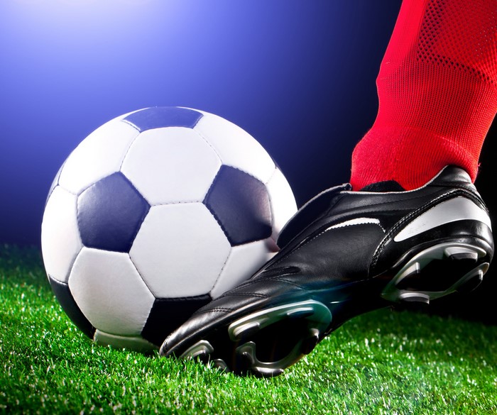 Soccer ball and player's foot in red sock