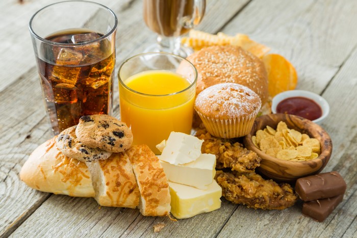 Assortment of unhealthy foods and drinks on wood