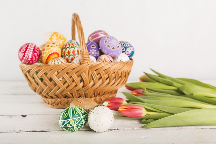 Easter eggs in a wicker basket with tulips