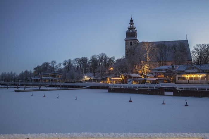 Winter evening in Naantali, Finland with frozen river and church