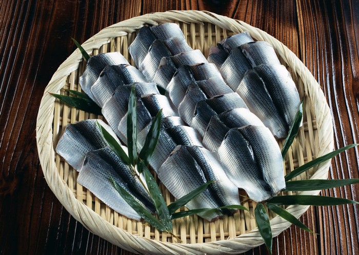 Raw fish fillets on a bamboo plate