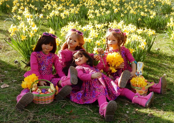 Dolls in pink dresses with Easter baskets in a field of daffodils