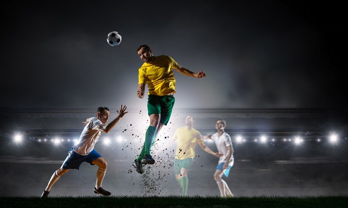 Men playing football and jumping for the ball