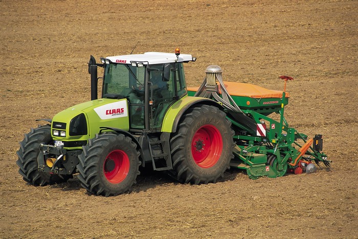 Claas Ares 826 RZ tractor with seeder in a field