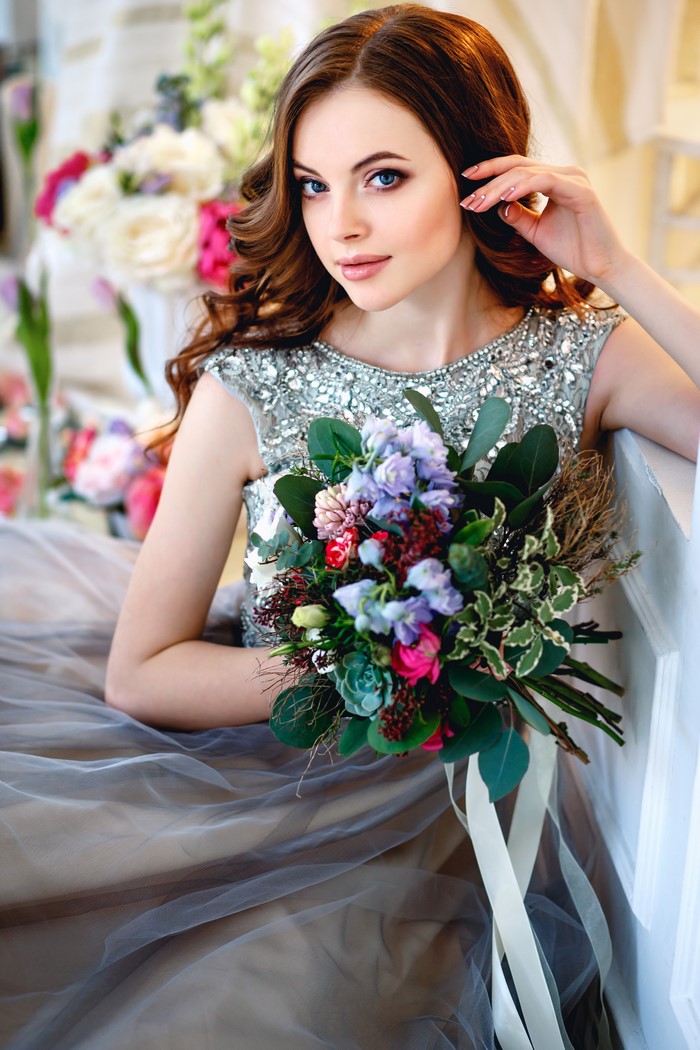 Woman with bouquet and floral background