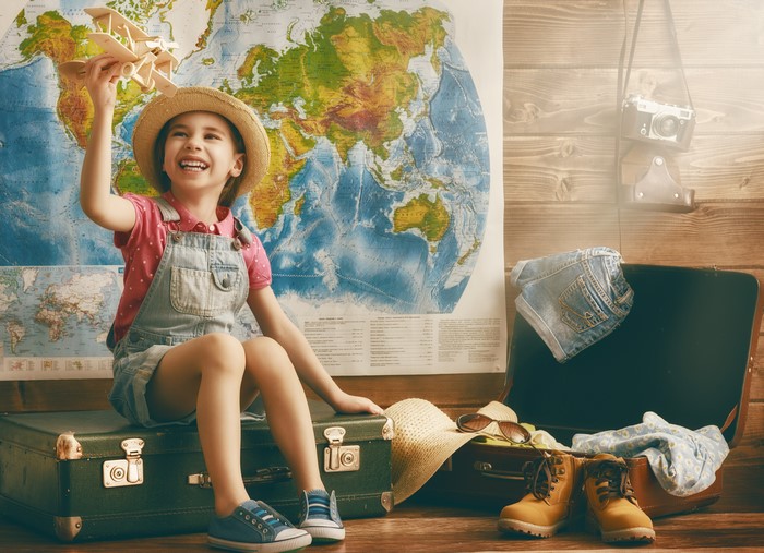 Little girl with toy airplane and suitcase