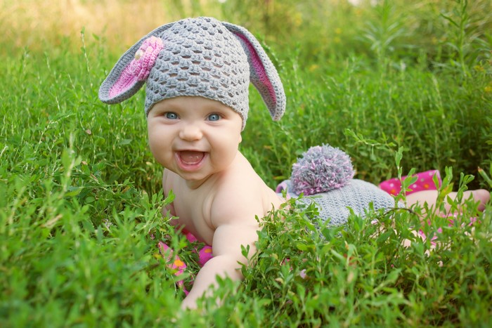 Baby in a bunny hat in the grass