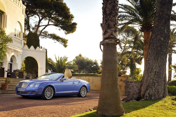 Blue Bentley Continental GTC Speed convertible parked by a villa