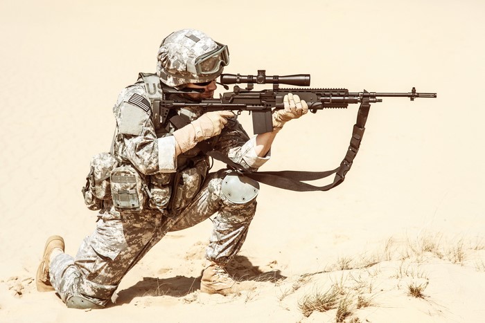 Soldier in uniform with assault rifle in desert