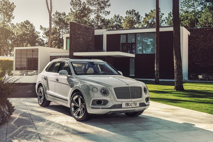 White Bentley Bentayga Hybrid parked in front of modern house
