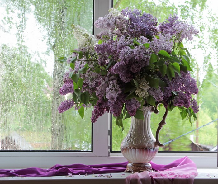 Bouquet of lilacs in a vase on a windowsill
